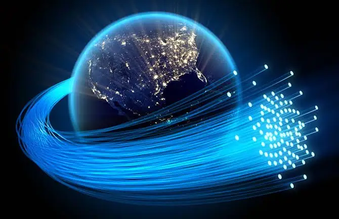 High-tech fiber optics forming around a digital Earth with illuminated city lights.