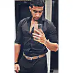 Professional man in black shirt taking a mirror selfie in an elevator.